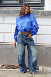 Kobaltblauw kort jasje gecombineerd met een blauwe wide leg jeans voor een casual outfit
