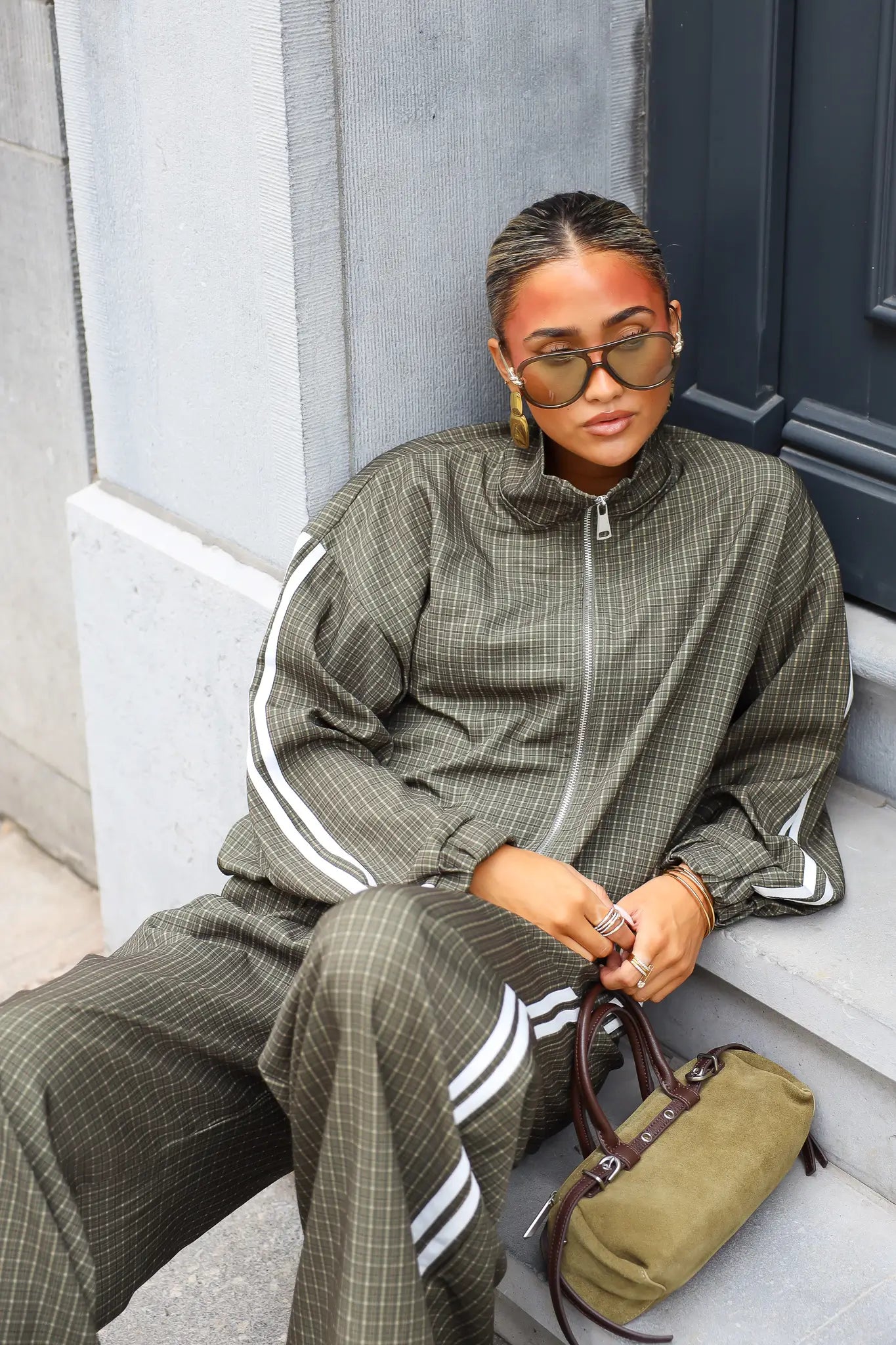 Geruite tracksuit dames met ritssluiting en witte strepen zittend