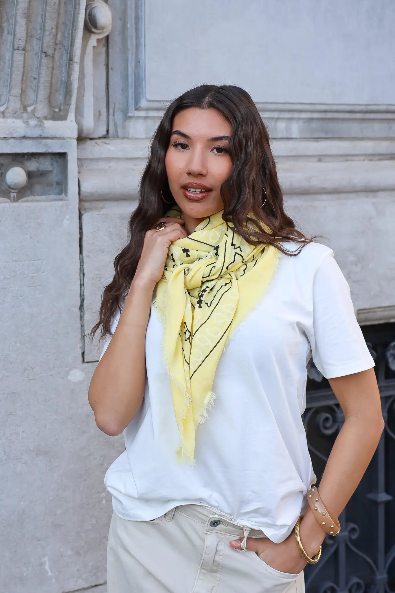 model draagt triangle sjaal geel groot met print bij wit t shirt