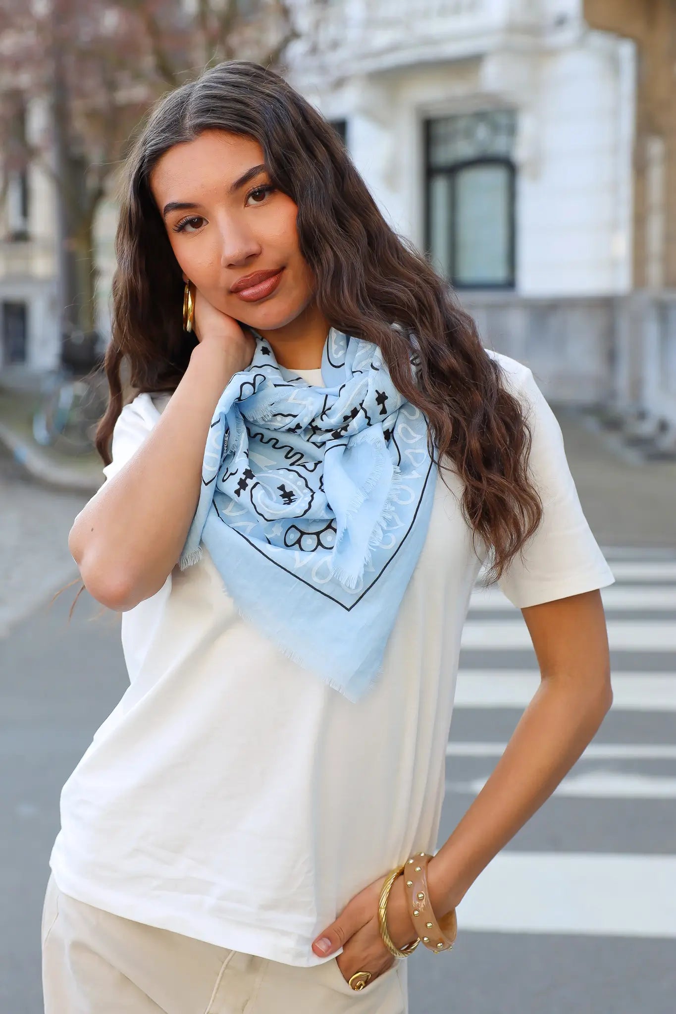model draagt triangle sjaal licht blauw groot met print bij wit t shirt