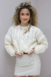 model met creme trui in studio recht van voren