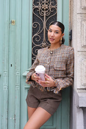 model draagt tweed jasje en laarzen op straat