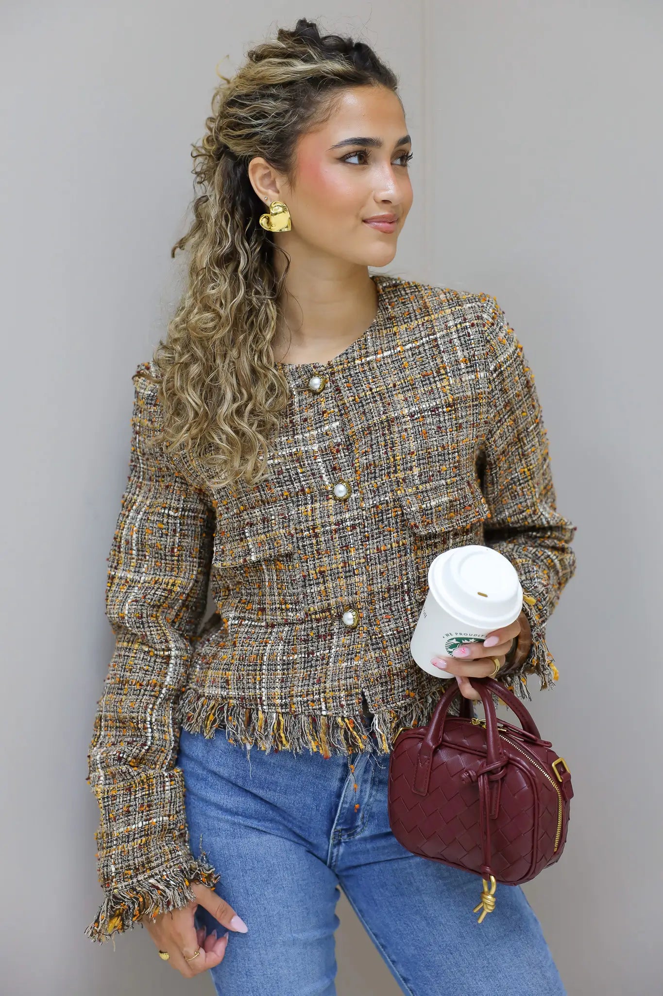 model poseert van dichtbij met tweed jasje in studio