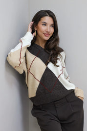 vrouw met bruin beige v hals ruit trui tegen lichte muur