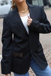 Close-up van de reworked Valentino blazer in zwart