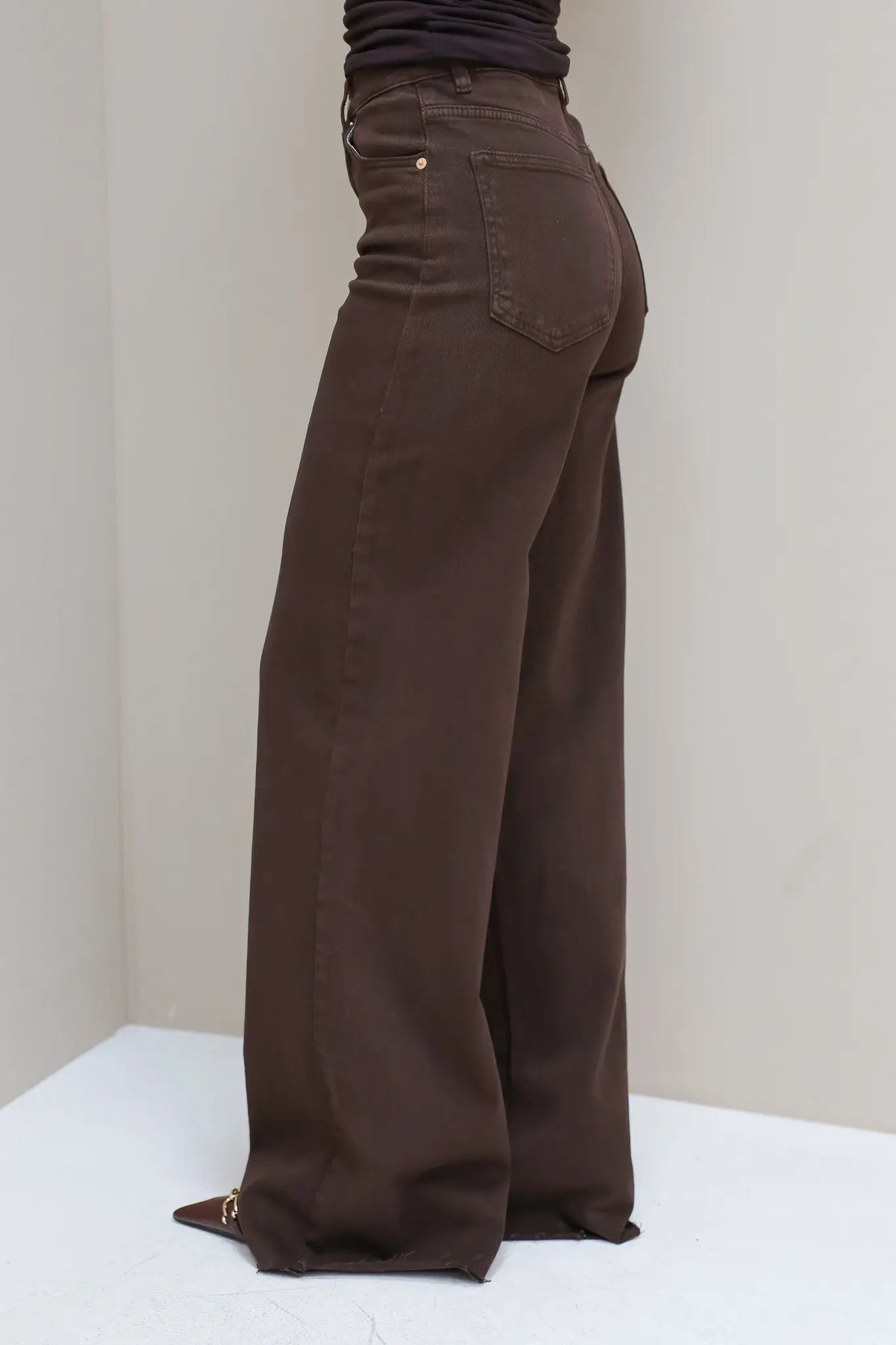 Zijaanzicht van de bruine jeans, focus op lengte en fit