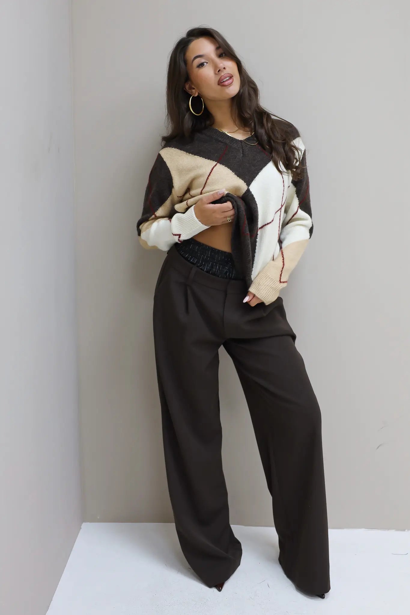 model in wijde bruine broek met boxerrand en beige trui