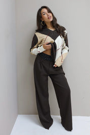 model in wijde bruine broek met boxerrand en beige trui