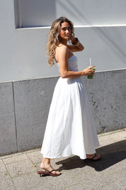 Witte maxi jurk gedragen met sandalen
