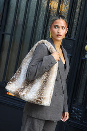 Zachte Bambi bonttas beige met lichte stippen en brede schouderband gedragen over een grijze blazer