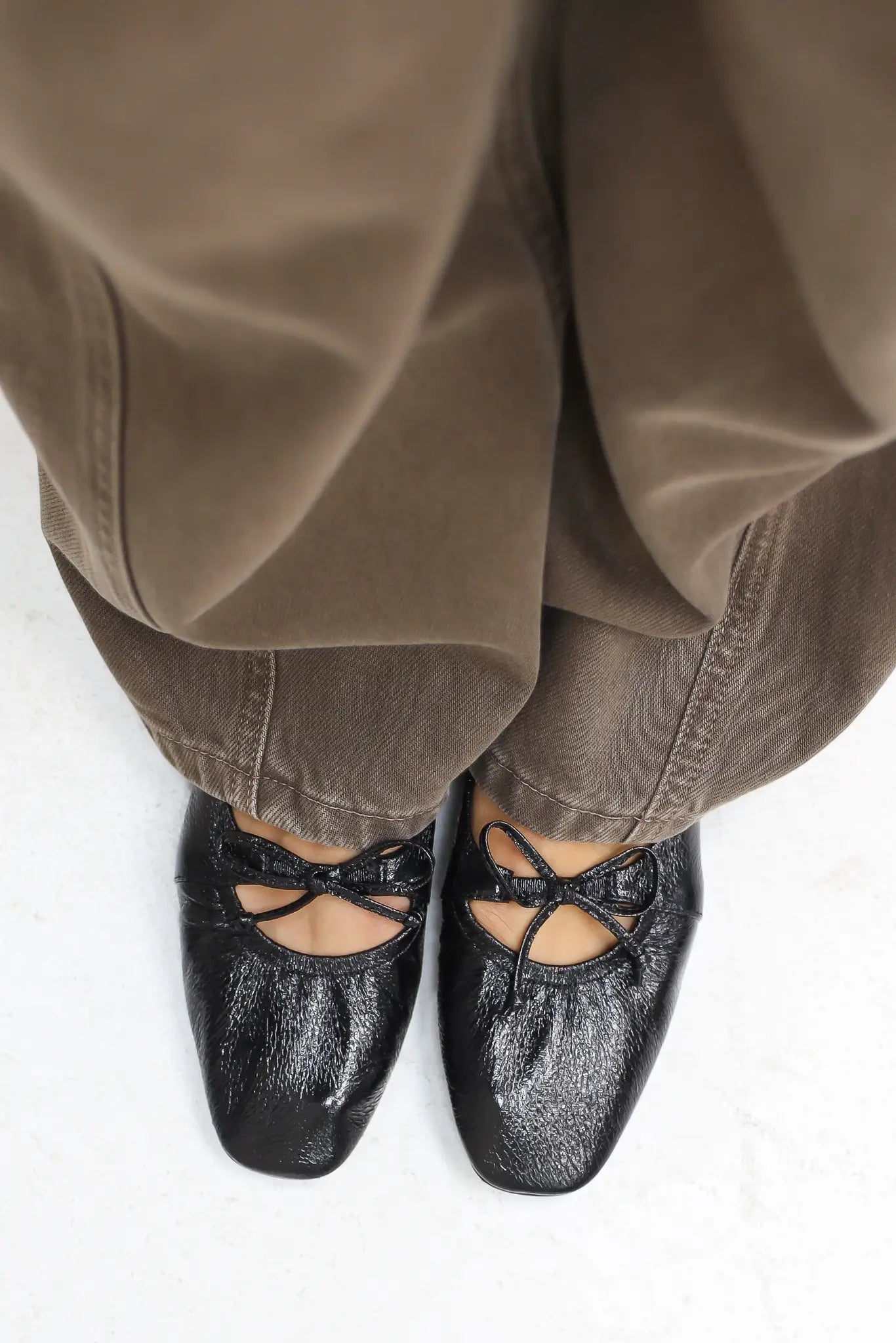 Bovenaanzicht van zwarte ballerina’s gedragen door model