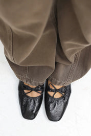 Bovenaanzicht van zwarte ballerina’s gedragen door model