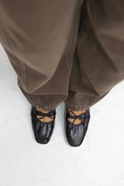 Model staat met zwarte ballerina’s van voren gefotografeerd