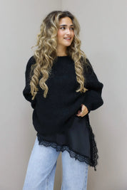 Model in zwarte cropped trui en bordeaux broek in studio