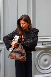 zwarte party top model staand bij deur terwijl ze tas opent